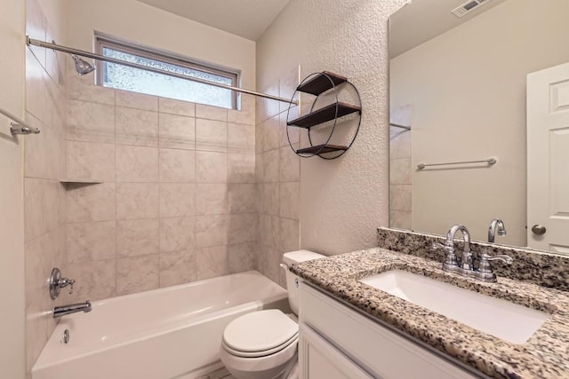 full bathroom with tiled shower / bath combo, vanity, and toilet