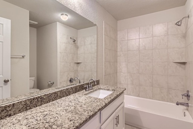 bathroom with a textured ceiling, vanity, bathtub / shower combination, and toilet