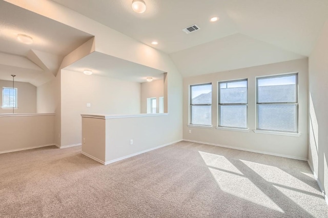 empty room featuring vaulted ceiling and light carpet