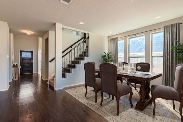 dining area featuring dark hardwood / wood-style floors and a textured ceiling