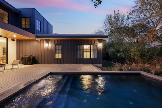 pool at dusk featuring a deck