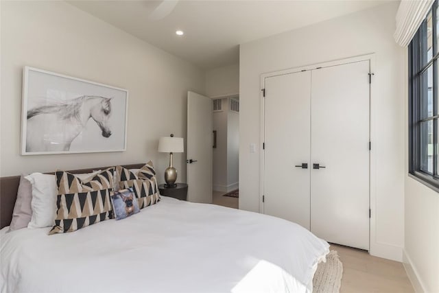 bedroom with light hardwood / wood-style flooring and a closet