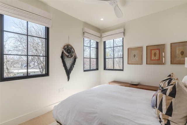 bedroom with ceiling fan and multiple windows