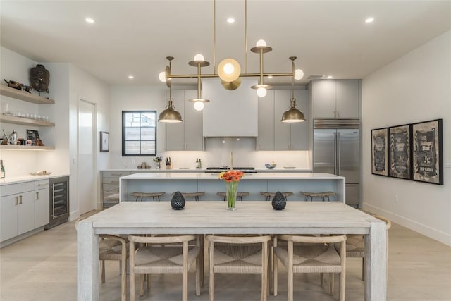1702 Bauerle Ave, Austin, TX 78704 - kitchen featuring stainless steel appliances, beverage cooler, gray cabinets, a center island, and light countertops