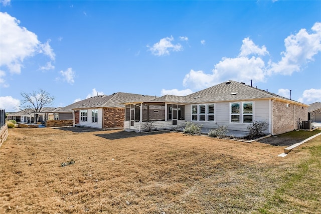 rear view of property featuring a yard and central AC unit