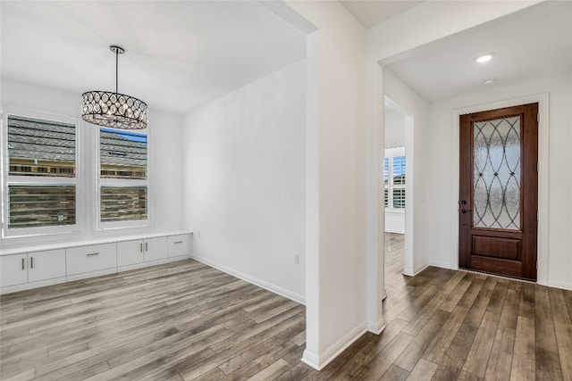 foyer entrance with a notable chandelier and wood-type flooring