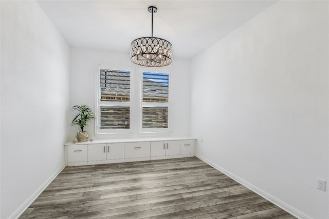 unfurnished dining area with light hardwood / wood-style floors and a notable chandelier