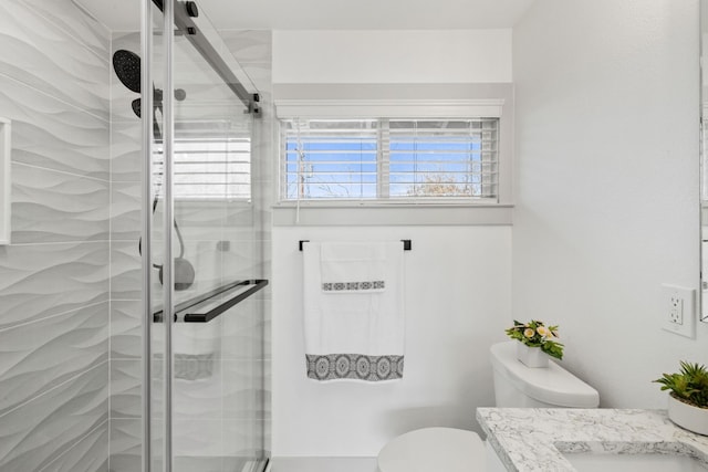 bathroom with vanity, a shower with shower door, and toilet