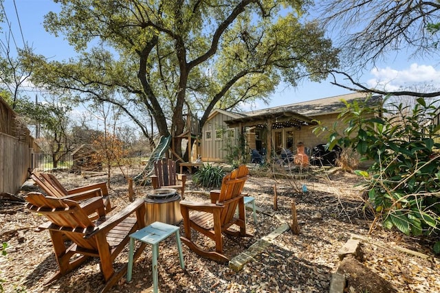 view of yard featuring a fire pit and fence