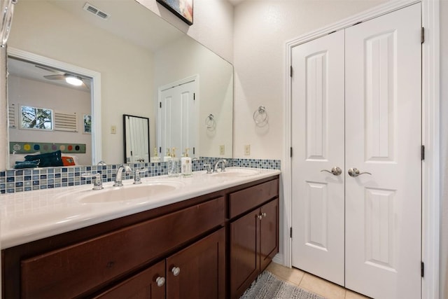 bathroom with tile patterned floors, visible vents, double vanity, and a sink