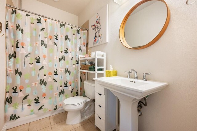 bathroom featuring shower / bath combo, tile patterned floors, and toilet