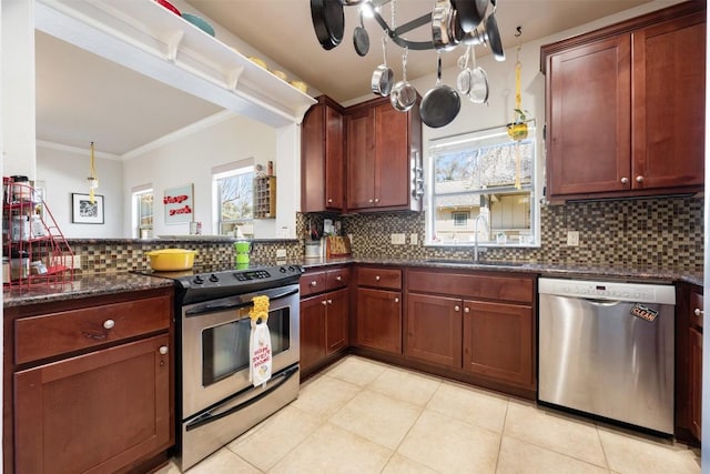 kitchen featuring sink, dark stone counters, decorative backsplash, stainless steel appliances, and crown molding