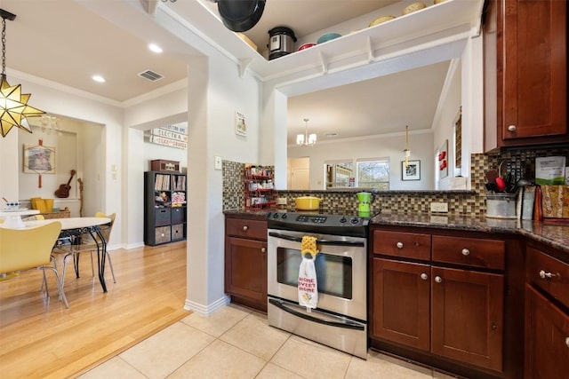 kitchen with stainless steel stove, crown molding, an inviting chandelier, hanging light fixtures, and tasteful backsplash