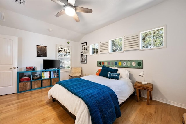 bedroom featuring vaulted ceiling, visible vents, baseboards, and light wood finished floors