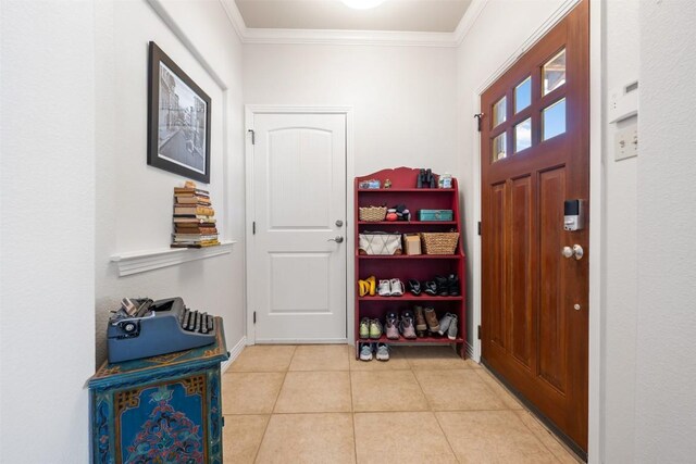 entryway with crown molding and light tile patterned floors