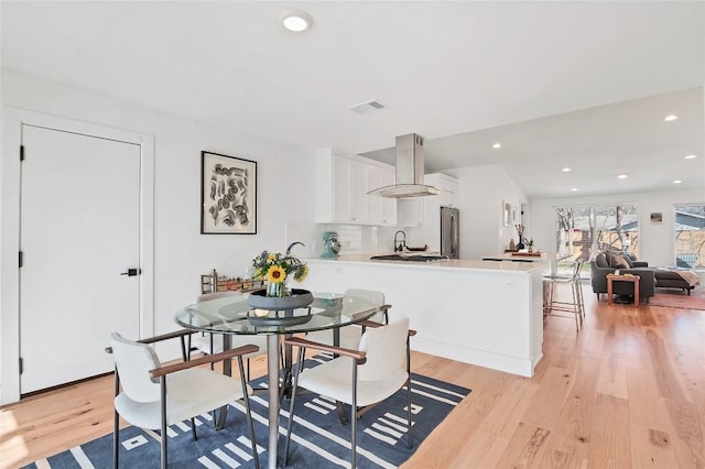 dining room with sink and light hardwood / wood-style flooring