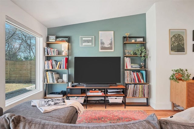 sitting room with hardwood / wood-style floors and vaulted ceiling