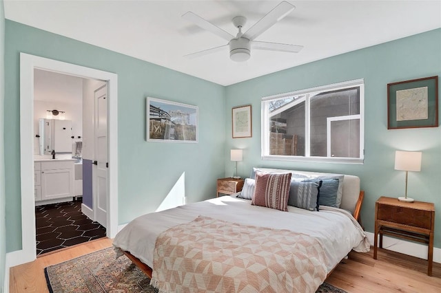 bedroom with hardwood / wood-style floors, ensuite bath, and ceiling fan