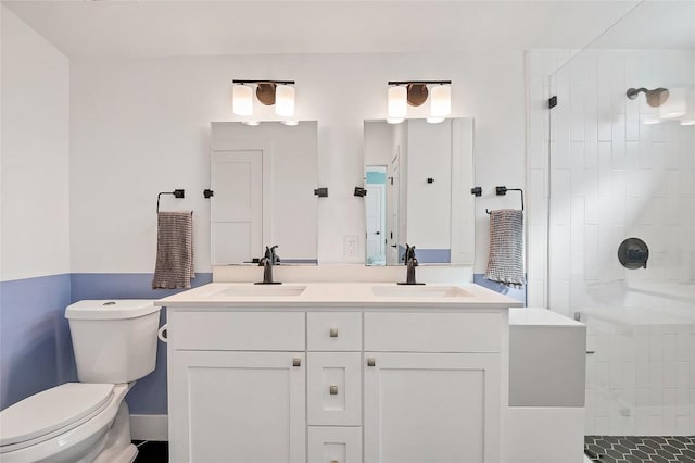 bathroom featuring vanity, tiled shower, and toilet