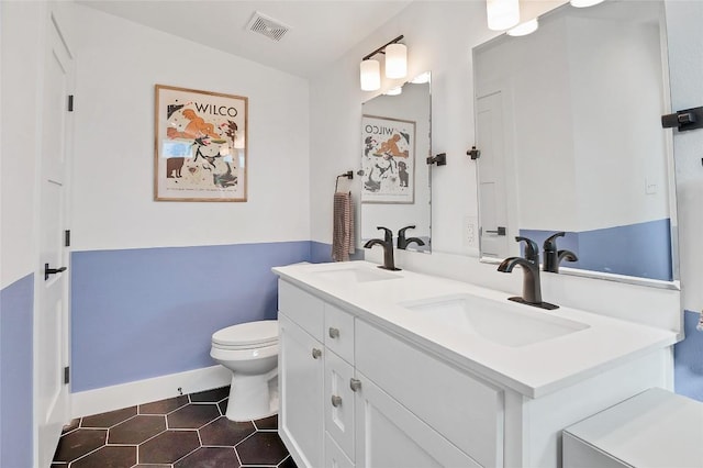 bathroom with tile patterned flooring, vanity, and toilet