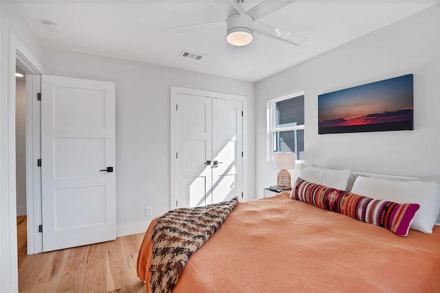 bedroom with ceiling fan, light wood-type flooring, and a closet