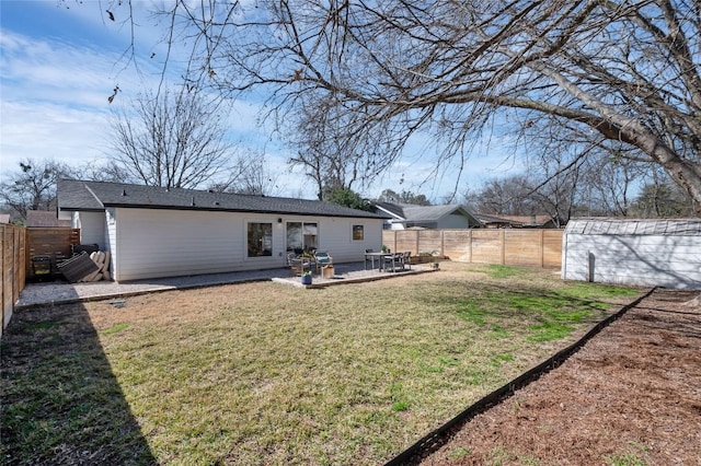 back of property with a shed, a lawn, and a patio