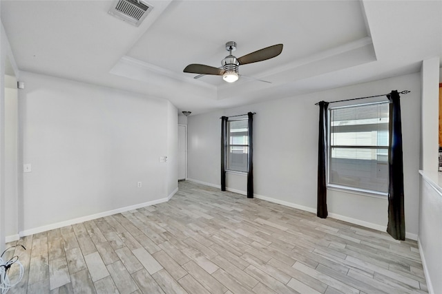 7405 Cayenne Ln, Austin, TX 78741 - empty room with a tray ceiling, ceiling fan, light wood-style flooring, and baseboards