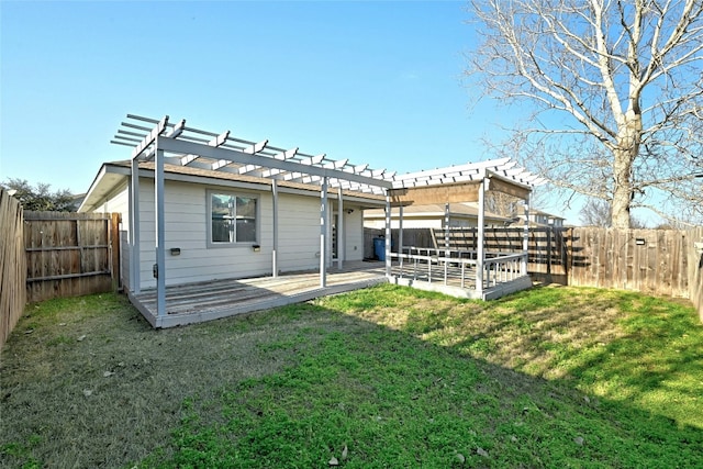 back of house featuring a wooden deck, a pergola, and a lawn