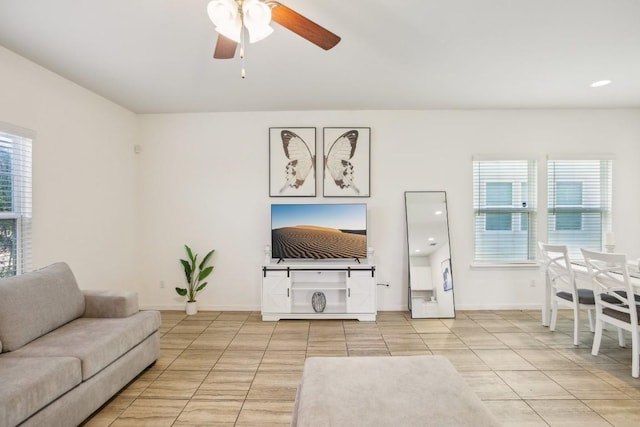 living room with light tile patterned flooring, ceiling fan, and a wealth of natural light