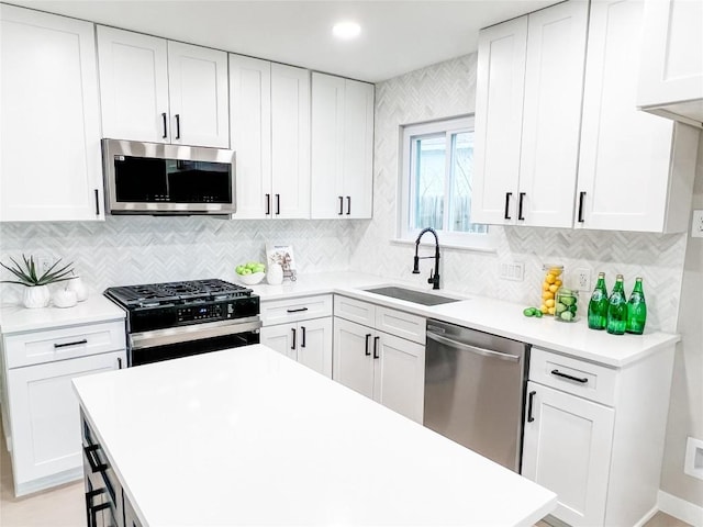 kitchen featuring tasteful backsplash, sink, stainless steel appliances, and white cabinets