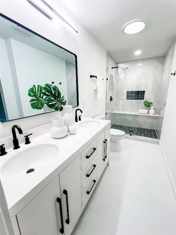 bathroom featuring vanity, tiled shower, and toilet