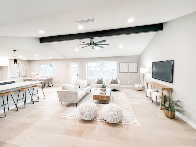 living room featuring ceiling fan, a wealth of natural light, and vaulted ceiling with beams