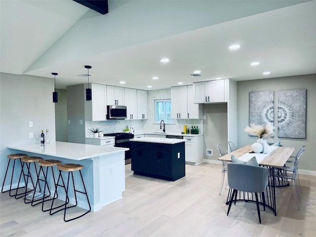 kitchen with white cabinetry, pendant lighting, gas stove, and kitchen peninsula