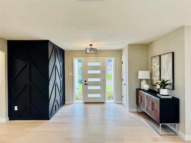 foyer entrance featuring an inviting chandelier and light hardwood / wood-style floors