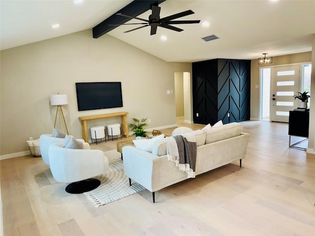 living room featuring ceiling fan with notable chandelier, light hardwood / wood-style flooring, and lofted ceiling with beams