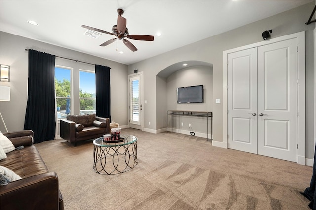 living room with light colored carpet and ceiling fan