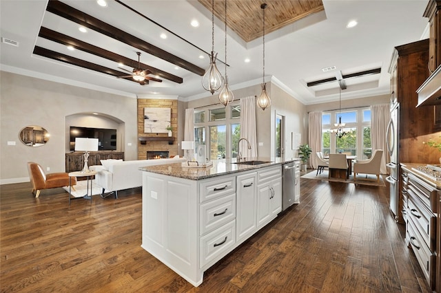 kitchen with white cabinetry, a tray ceiling, decorative light fixtures, and sink