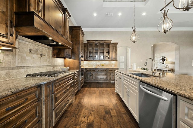 kitchen with sink, appliances with stainless steel finishes, white cabinetry, hanging light fixtures, and light stone counters