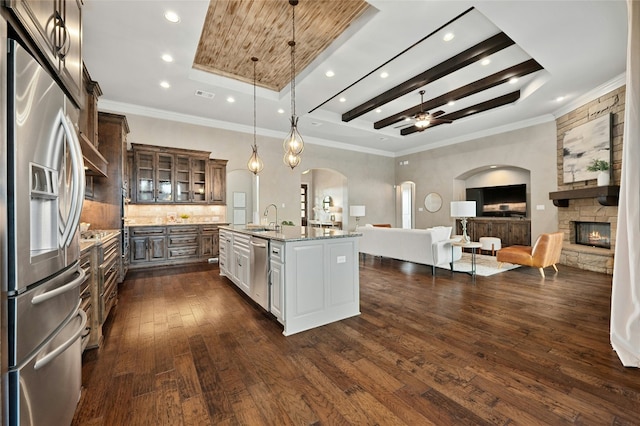 kitchen featuring sink, hanging light fixtures, a center island with sink, stainless steel appliances, and white cabinets