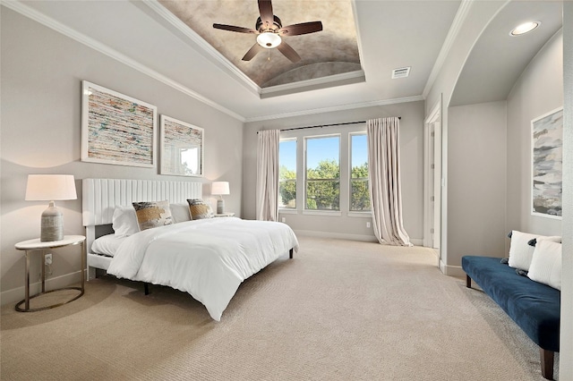 bedroom featuring ceiling fan, ornamental molding, a raised ceiling, and carpet floors