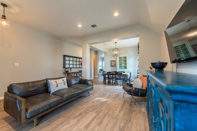 living room featuring lofted ceiling and light wood-type flooring