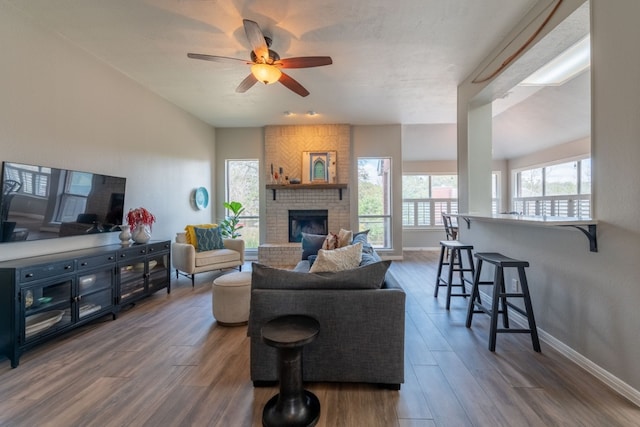 living room with ceiling fan, a fireplace, and dark hardwood / wood-style flooring