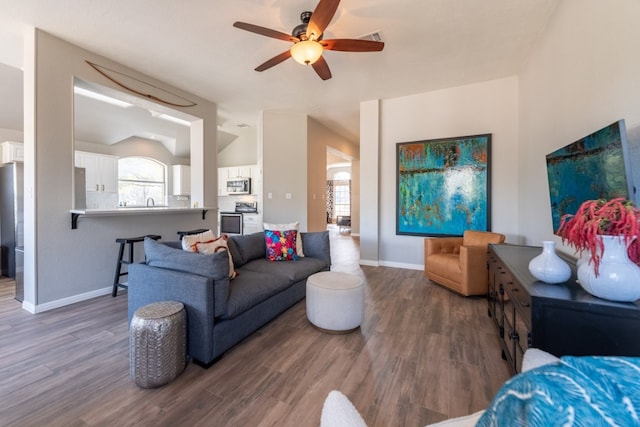 living room featuring vaulted ceiling, dark hardwood / wood-style floors, and ceiling fan