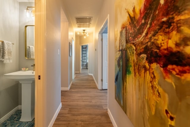 hallway featuring hardwood / wood-style flooring and sink