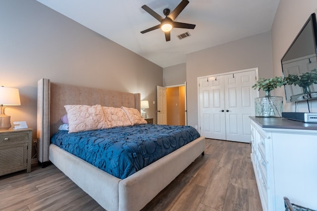 bedroom featuring lofted ceiling, a closet, dark hardwood / wood-style floors, and ceiling fan