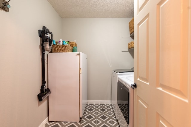 clothes washing area with independent washer and dryer and a textured ceiling