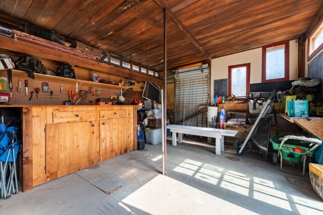 miscellaneous room featuring wooden ceiling, concrete floors, and a workshop area