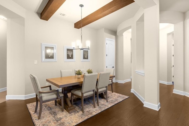 dining space with dark hardwood / wood-style floors, an inviting chandelier, and beam ceiling