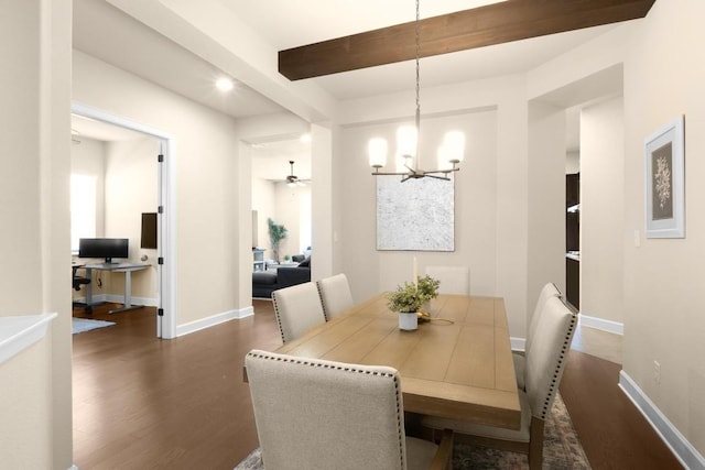 dining room with dark wood-type flooring, ceiling fan with notable chandelier, and beam ceiling