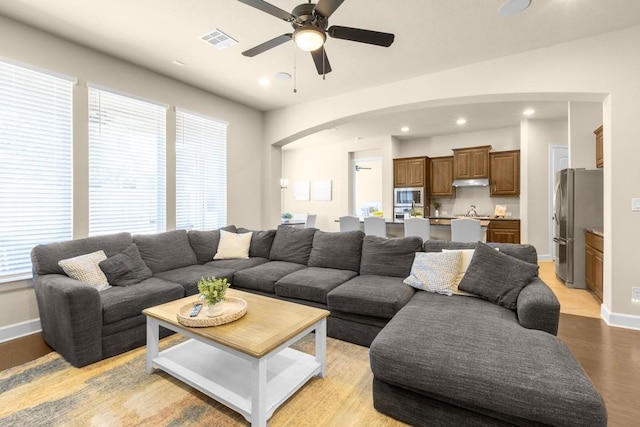 living room featuring ceiling fan and light wood-type flooring